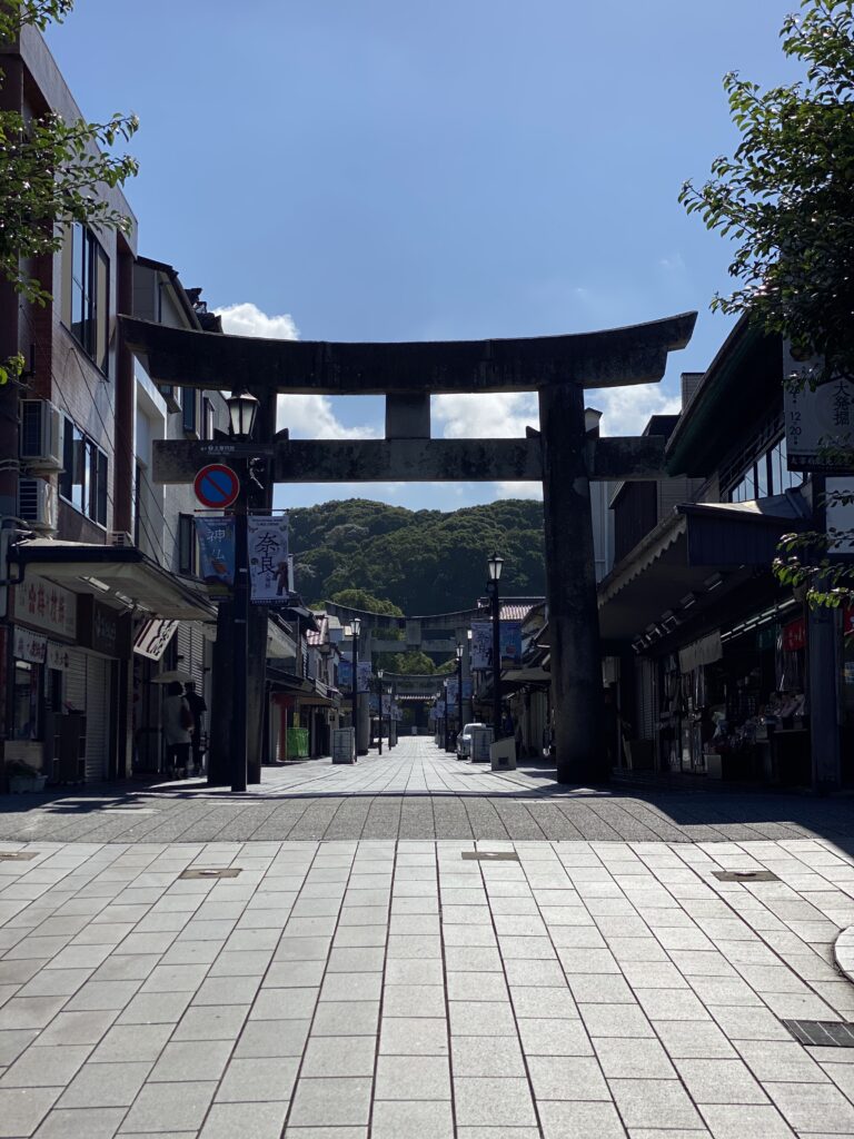 A stone torii gate over the Omotesando shopping approach to Dazaifu Tenmangu early in the morning